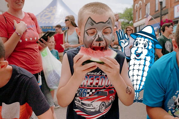 Boys eating watermelon at a fair