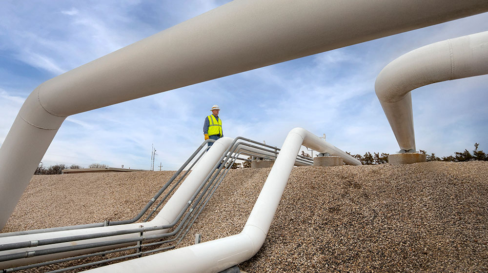 Man standing by pipes.